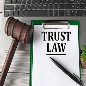 Trust law document on clipboard with judge gavel